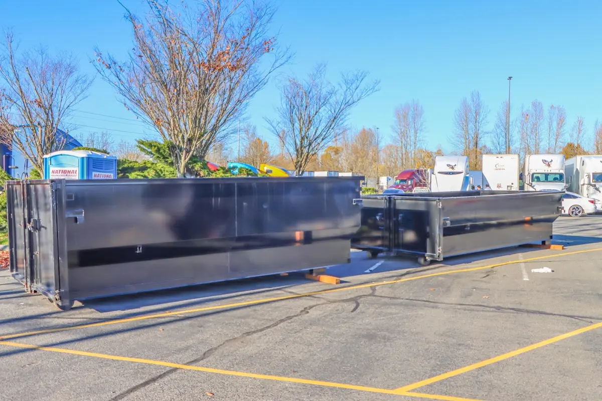 Professional dumpster rental service with roll-off container on residential driveway in Barstow